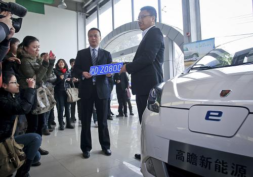 1月23日上午,4S店工作人員向首位獲得免費車牌的車主錢先生(左)交付車牌。當(dāng)日,上海首輛新能源汽車交車儀式在嘉定區(qū)國際汽車城舉行。上午10時左右,一輛掛著上海新能源車專屬車牌“滬D·Z0800”的上汽榮威E50電動車從嘉定區(qū)國際汽車城駛出,標(biāo)志著上海首輛“免費上牌”新能源汽車上路。上海新能源汽車的申領(lǐng)人只需交牌照工本費100元、行駛證費用15元、登記證書費用10元共125元,無需參與車牌額度拍賣。車牌以“滬D·Z”打頭,實行一車一牌制度,不予辦理退牌業(yè)務(wù),車牌不能過戶、不能轉(zhuǎn)讓。新華社發(fā)