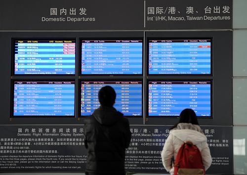 1月23日,旅客在北京首都國(guó)際機(jī)場(chǎng)3號(hào)航站樓查看航班信息。新華社記者 羅曉光 攝