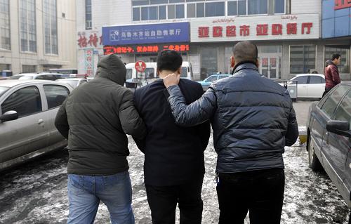 1月23日,警方將犯罪嫌疑人龐某(中)帶回派出所準(zhǔn)備審問(wèn)。新華社記者 趙戈 攝