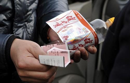 1月23日,犯罪嫌疑人龐某將車(chē)票放在飲料瓶外側(cè),并用包裝紙隱蔽好。新華社記者 趙戈 攝