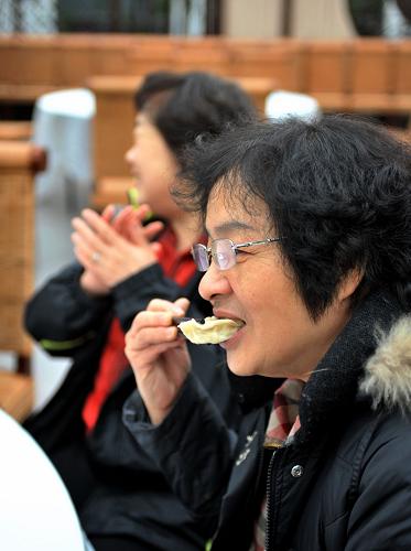 1月23日,會(huì)員們品嘗自己包的餃子。新華社發(fā)(張晨霖?cái)z)