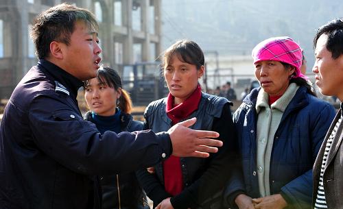 1月23日,一名工作人員在安撫遇難礦工的親友。新華社記者 楊楹 攝