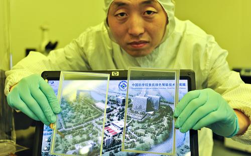 1月24日,中科院重慶綠色智能技術(shù)研究院的一名研究人員在展示單層石墨烯產(chǎn)品(右為單層石墨烯)的超強透光性。