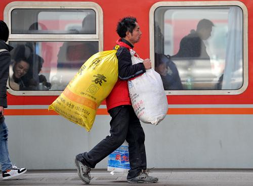 1月25日,一名旅客扛著行李在南京火車(chē)站趕乘列車(chē)。新華社發(fā)