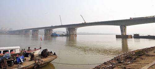 這是1月26日拍攝的主體完工的長沙湘府路湘江大橋。 長沙湘府路湘江大橋日前主體完工,目前,該橋正進(jìn)行主橋橋面、部分匝道和大量附屬結(jié)構(gòu)施工,預(yù)計(jì)春節(jié)建成通車。據(jù)介紹,湘府路湘江大橋工程全長2.655公里,主線橋梁全長1.785公里,概算總投資7.84億元。大橋建成后將對疏散長沙中心區(qū)交通流量、緩解中心區(qū)交通矛盾起到明顯作用。 新華社記者 龍弘濤 攝