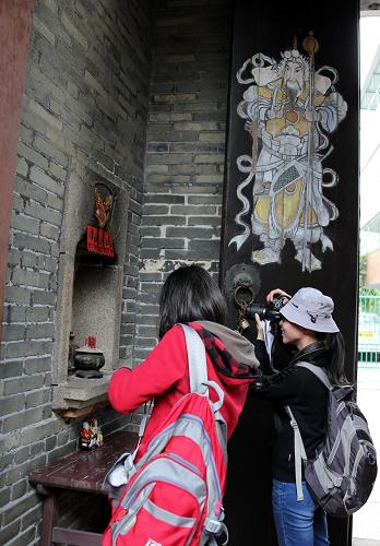 1月26日,兩位考察團(tuán)成員在香港元朗廈村鄧氏宗祠拍照。新華社記者李鵬攝