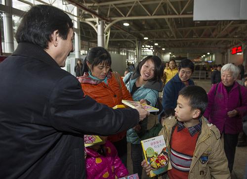 1月29日,重慶出版集團(tuán)的工作人員在重慶市火車北站向旅客發(fā)放讀物。據(jù)了解,重慶出版集團(tuán)當(dāng)日在重慶市火車北站的候車室內(nèi)向旅客發(fā)放300多個(gè)品種、價(jià)值10萬(wàn)余元的近6000冊(cè)圖書。新華社記者 陳誠(chéng) 攝