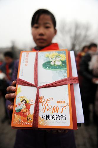 1月29日,鄭州市中牟縣官渡鎮(zhèn)官渡橋村,一名小學(xué)生展示她收到的圖書禮包?;顒?dòng)中,官渡橋村村民共收到814個(gè)品種、9800余冊(cè)的圖書和雜志。新華社記者 陳誠(chéng) 攝