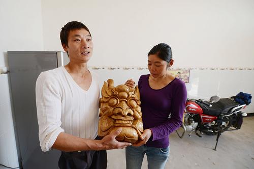 2月1日,胡昌勝(左)在介紹朋友為新居落成送來的當(dāng)?shù)靥厣膬婢?。新華社記者 周科 攝