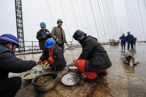 2月5日,施工工人在大橋橋面上吃午飯。新華社記者 徐昱 攝