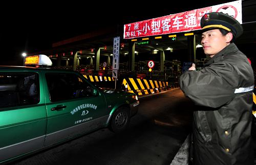 2月9日,在福建福州,工作人員引導(dǎo)進(jìn)入高速的車(chē)輛。 新華社記者 魏培全 攝