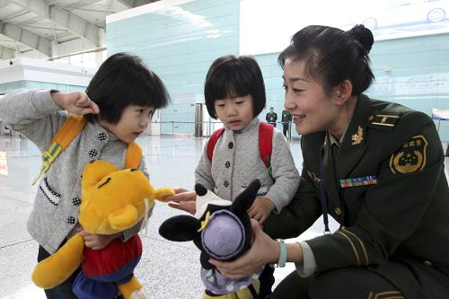 2月9日,遼寧大連周水子邊防檢查站的女警官將新年禮物送給兩名入境的小朋友。當(dāng)日是農(nóng)歷除夕,遼寧大連周水子邊防檢查站的執(zhí)勤人員放棄與家人團(tuán)圓的機(jī)會(huì),日夜輪班堅(jiān)守在工作崗位。新華社發(fā)(孫模同 攝)