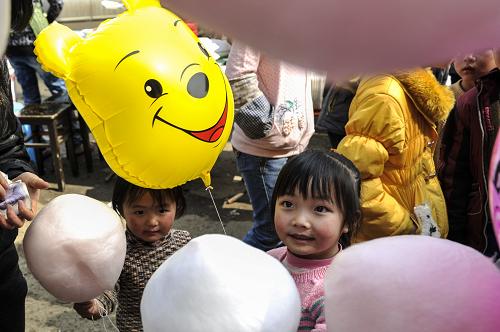 2月10日,在畢節(jié)市納雍縣維新鎮(zhèn)的總溪河廟會(huì)上,一名小女孩在購(gòu)買棉花糖。當(dāng)日是大年初一。貴州畢節(jié)烏蒙山區(qū)處處洋溢著“年味兒”,眾多集貿(mào)市場(chǎng)熱鬧非凡,年味十足,種類繁多的商品吸引眾多農(nóng)民前來(lái)趕集。新華社記者 歐東衢 攝