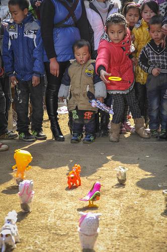 2月10日,在畢節(jié)市納雍縣維新鎮(zhèn)的總溪河廟會(huì)上,一名小女孩在玩“套圈”游戲。新華社記者 歐東衢 攝
