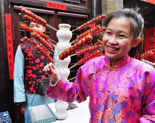 2月10日,一名老撾留學(xué)生在山東省淄博市周村古城品嘗糖葫蘆。新華社發(fā)(董乃德 攝)