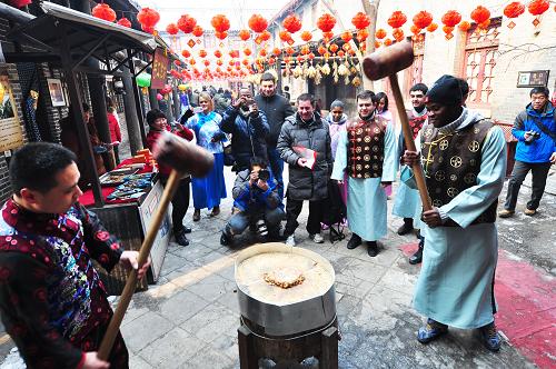 2月10日,外國(guó)留學(xué)生在山東省淄博市周村古城體驗(yàn)打糖糕。新華社發(fā)(董乃德 攝)