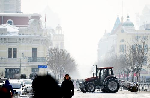2月10日,一臺(tái)農(nóng)用拖拉機(jī)在哈爾濱市區(qū)為道路清雪。新華社記者 王建威 攝