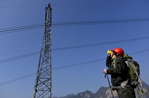 2月10日,湖北電力檢修特巡隊員在用測距儀測量導(dǎo)線與樹木的安全距離。當(dāng)日是農(nóng)歷大年初一,湖北電力檢修分公司宜昌檢修分部運檢職工在三峽庫區(qū)秭歸縣茅坪鎮(zhèn)羅家村對500千伏峽林一二三回線路進(jìn)行巡視。500千伏峽林一二三回線路是三峽電力外送線路的收官之作,因通道有限,線路途經(jīng)的羅家村地段海拔高、地勢險。為確保湖北省宜昌市、恩施土家族苗族自治州境內(nèi)的24條500千伏超高壓輸電線路安全運行,當(dāng)?shù)仉娏z修工作人員春節(jié)期間堅守工作崗位,為三峽電外送、西電東送等超高壓輸電線路的安全運行保駕護(hù)航,確保春節(jié)期間電力的供應(yīng)。新華社發(fā)(吳煒 攝)