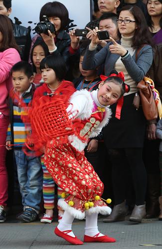 2月23日,在福建廈門中山路步行街,廈門市思明區(qū)梧村小學(xué)的學(xué)生表演舞蹈《紅紅的中國結(jié)》。新華社記者 金立旺 攝
