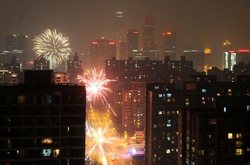 2月24日晚,煙花在霧霾籠罩的北京東三環(huán)綻放。新華社記者 羅曉光 攝