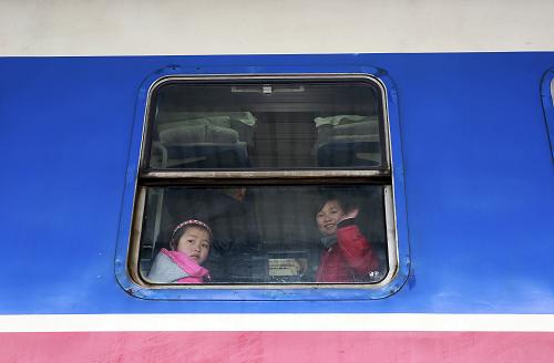 3月2日,在貴州省凱里市火車站,兩名先心病患兒在列車上與送行的家人告別。新華社發(fā)(黃曉海 攝)