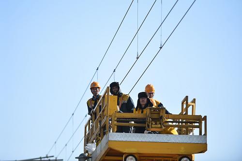 3月14日,在察爾汗鹽湖區(qū)段,陳志岐(左一)和同事乘作業(yè)車趕往下一個電線桿。新華社發(fā)(吳剛 攝)