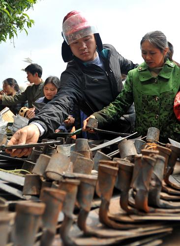 3月19日,在廣西桂林市灌陽縣濱江路,當(dāng)?shù)剞r(nóng)民在選購鐵具。新華社記者 陸波岸 攝