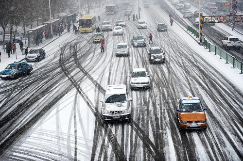 3月21日,哈爾濱市某主干道上路面的雪被軋出了一道道車印。新華社記者 王凱 攝