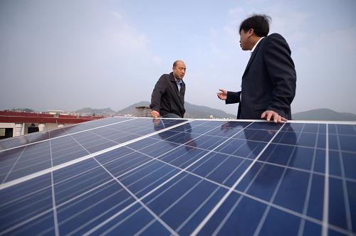 供電部門(mén)工作人員(右)和朱建兵的家人在查看設(shè)備工作情況(3月22日攝)。新華社記者周密攝