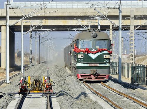 3月22日,鋪設(shè)砟石的列車在津秦鐵路客運專線河北秦皇島開發(fā)區(qū)段剛鋪設(shè)的鐵路上鋪砟石。新華社發(fā)(劉學忠 攝)