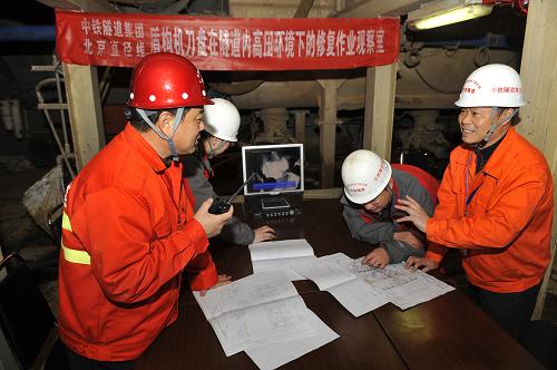 3月27日,中鐵隧道集團(tuán)的工程技術(shù)人員在隧道內(nèi)的修復(fù)作業(yè)觀察室通過(guò)視頻監(jiān)控指導(dǎo)施工人員在高壓環(huán)境下作業(yè)。新華社記者 魯鵬 攝