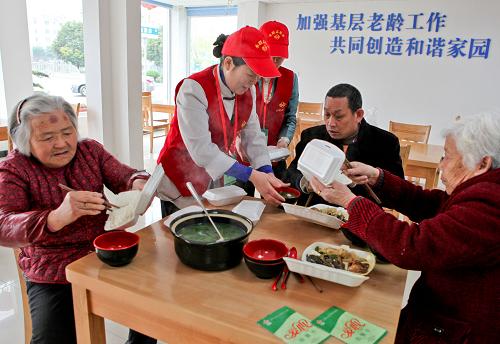 兩名志愿者在為持助餐卡的老人及殘疾人服務(wù)(3月23日攝)。新華社記者 楊磊 攝