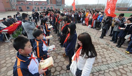 3月28日,大學(xué)生志愿者向小學(xué)生贈送書籍等學(xué)生用品。當(dāng)日,遼寧大學(xué)50余名大學(xué)生志愿者來到沈陽市于洪區(qū)八家子小學(xué),開展關(guān)愛農(nóng)民工子女志愿服務(wù)活動。大學(xué)生們向八家子小學(xué)捐贈了募集到的書籍、文具等學(xué)習(xí)用品,并深入到各個班級開展了包括書法、繪畫、舞蹈、手語、折紙等在內(nèi)的文藝課堂教學(xué)活動。新華社記者 楊青 攝