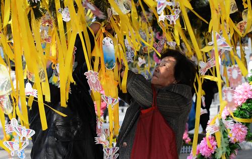 3月30日,前來北京市八寶山人民公墓掃墓的市民將許愿卡掛上許愿樹。新華社發(fā)(王全超 攝)