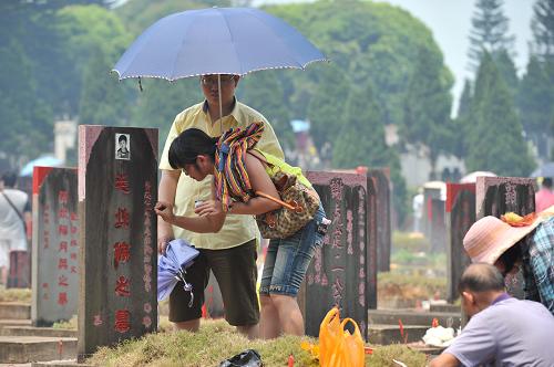 4月4日,祭掃的市民在海口市顏春嶺安樂(lè)園內(nèi)的一處墓碑前描字。新華社記者 施鰻珂 攝