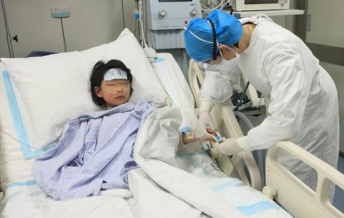 北京地壇醫(yī)院工作人員在ICU病房照顧患者(4月12日攝)。新華社發(fā)(王雪 攝)