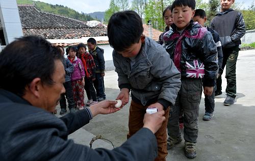 4月12日,湖北省宣恩縣二坪村小學的學生在領取營養(yǎng)餐。在這所學校,運輸營養(yǎng)餐的費用要比營養(yǎng)餐本身在價格高三四倍。新華社發(fā)(宋文 攝)