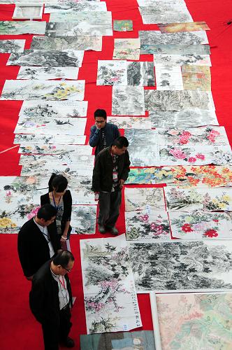 4月15日,在“希望·圓夢”杯全國書畫作品展評審會現(xiàn)場,評委及工作人員從鋪滿地毯的國畫作品旁走過。新華社記者 范培珅 攝