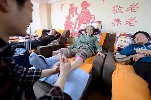 4月16日,在合肥市三里庵居家養(yǎng)老服務(wù)中心,工作人員在幫趙金娥老人做足療。 近兩年來(lái),安徽省合肥市三里庵街道60歲以上老齡人口已達(dá)1.07萬(wàn)人,占街道總?cè)丝诘?0%以上,轄區(qū)人口呈現(xiàn)老齡化、空巢化的特點(diǎn),社會(huì)養(yǎng)老服務(wù)供需矛盾日益凸顯。為建立與人口老齡化相適應(yīng)的居家養(yǎng)老服務(wù)體系,三里庵街道建立了合肥市最大的居家養(yǎng)老服務(wù)中心,該中心內(nèi)設(shè)醫(yī)療保健室、書畫閱覽室、娛樂(lè)活動(dòng)室、營(yíng)養(yǎng)餐廳等多個(gè)功能區(qū),滿足轄區(qū)老年人的各項(xiàng)需求。同時(shí)該街道還整合愛(ài)心企業(yè)、專職社工、志愿者、共建單位等資源,為轄區(qū)老人提供家政、醫(yī)療、送餐等上門服務(wù)。新華社發(fā)(張端 攝)