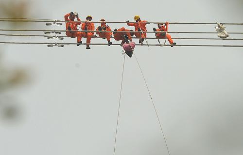 4月16日,幾名電力工人在黃河邊140多米的高空作業(yè)現(xiàn)場(chǎng)吃午餐。新華社記者趙鵬攝