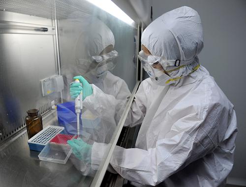 4月16日,新鄉(xiāng)市疾控中心實驗室工作人員對H7N9檢測試劑進行操作。新華社記者 李博 攝