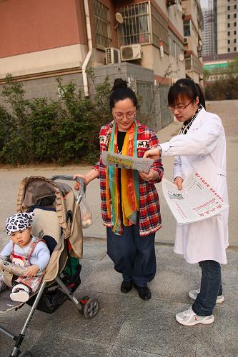 4月16日,河北省衡水市第五人民醫(yī)院的醫(yī)務(wù)人員在寶云溫泉花園小區(qū)為居民們發(fā)放H7N9禽流感防控宣傳材料。新華社記者 白林 攝