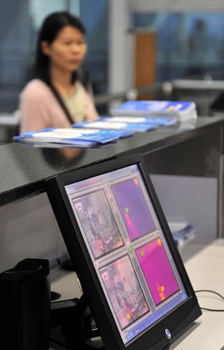 4月17日,廣州白云國際機場檢驗檢疫局出境旅客檢疫通道設置的紅外測溫設備監(jiān)控旅客的體溫。新華社記者 文浩 攝