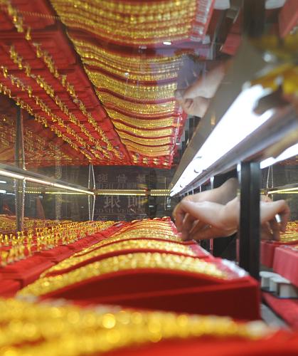 4月18日,江蘇無(wú)錫一家金店工作人員在擺放黃金飾品。連日來,受近期國(guó)際黃金價(jià)格持續(xù)下跌的影響,我國(guó)各地金店紛紛宣布下調(diào)黃金價(jià)格,吸引了眾多消費(fèi)者入店“搶金”。新華社發(fā)(張立偉 攝)