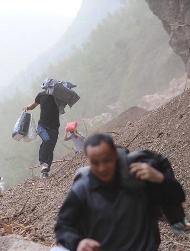 4月20日,寶盛鄉(xiāng)群眾快速通過山體塌方地段。新華社記者 江宏景 攝