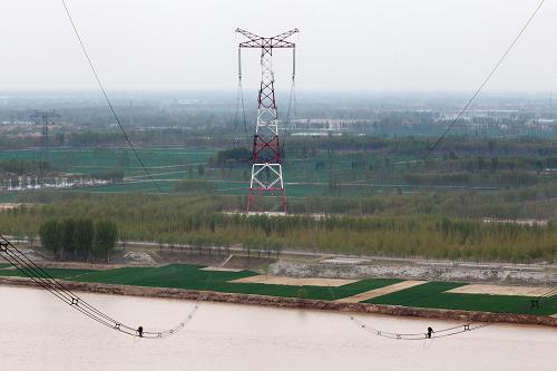 國家電網(wǎng)山東電力公司檢修人員在百米高空進(jìn)行線路巡查檢修(4月19日攝)。近日,國家電網(wǎng)山東電力公司開始對黃河大跨越段輸電線路±660千伏進(jìn)行停電巡查檢修。為節(jié)省時間,檢修人員從早7時到晚6時不間斷作業(yè),在120多米高鐵塔線路上進(jìn)行簡單午餐補(bǔ)給,確保檢修盡早完成。此次檢修歷時10天,將提升山東電網(wǎng)安全運(yùn)行和“迎峰度夏”的電力供應(yīng)提供有力保障。新華社發(fā)(徐可 攝)