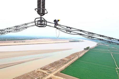 國家電網(wǎng)山東電力公司檢修人員在百米高空進(jìn)行線路巡查檢修(4月19日攝)。新華社發(fā)(徐可 攝)