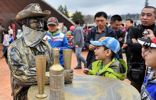 4月30日,小朋友們在長影世紀(jì)城中與“活體雕塑”互動。新華社記者 王昊飛 攝