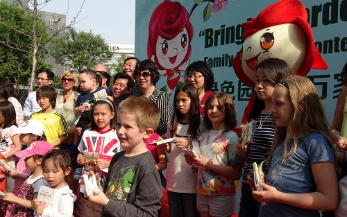 5月4日,外國友人及家屬代表在“綠色園博進萬家”活動現(xiàn)場領(lǐng)取園博會花種。新華社記者 李欣 攝