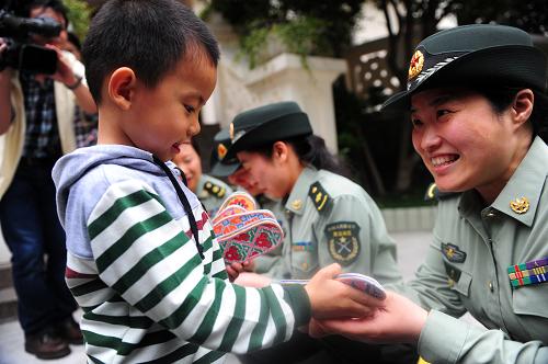 5月10日,小弘揚(yáng)把媽媽楊啟菊做的感恩鞋墊送給“兵媽媽”們。新華社記者 沈鵬 攝